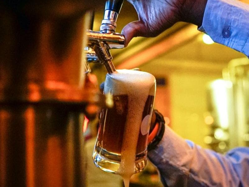 Beer being poured, foam overflowing the glass